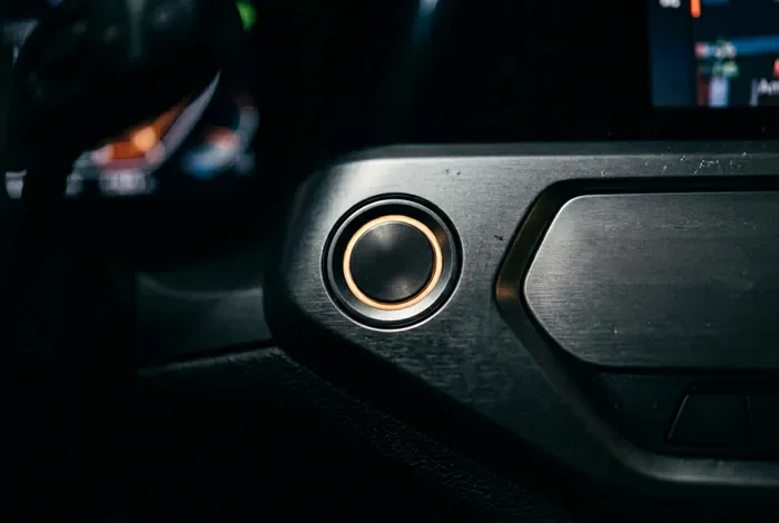 Peugeot 308 ne démarre plus en mode économie : solutions Détail macro du bouton de démarrage d'une voiture moderne